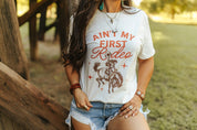 Ain't My First Rodeo Cowgirl Graphic TeeNaturalS