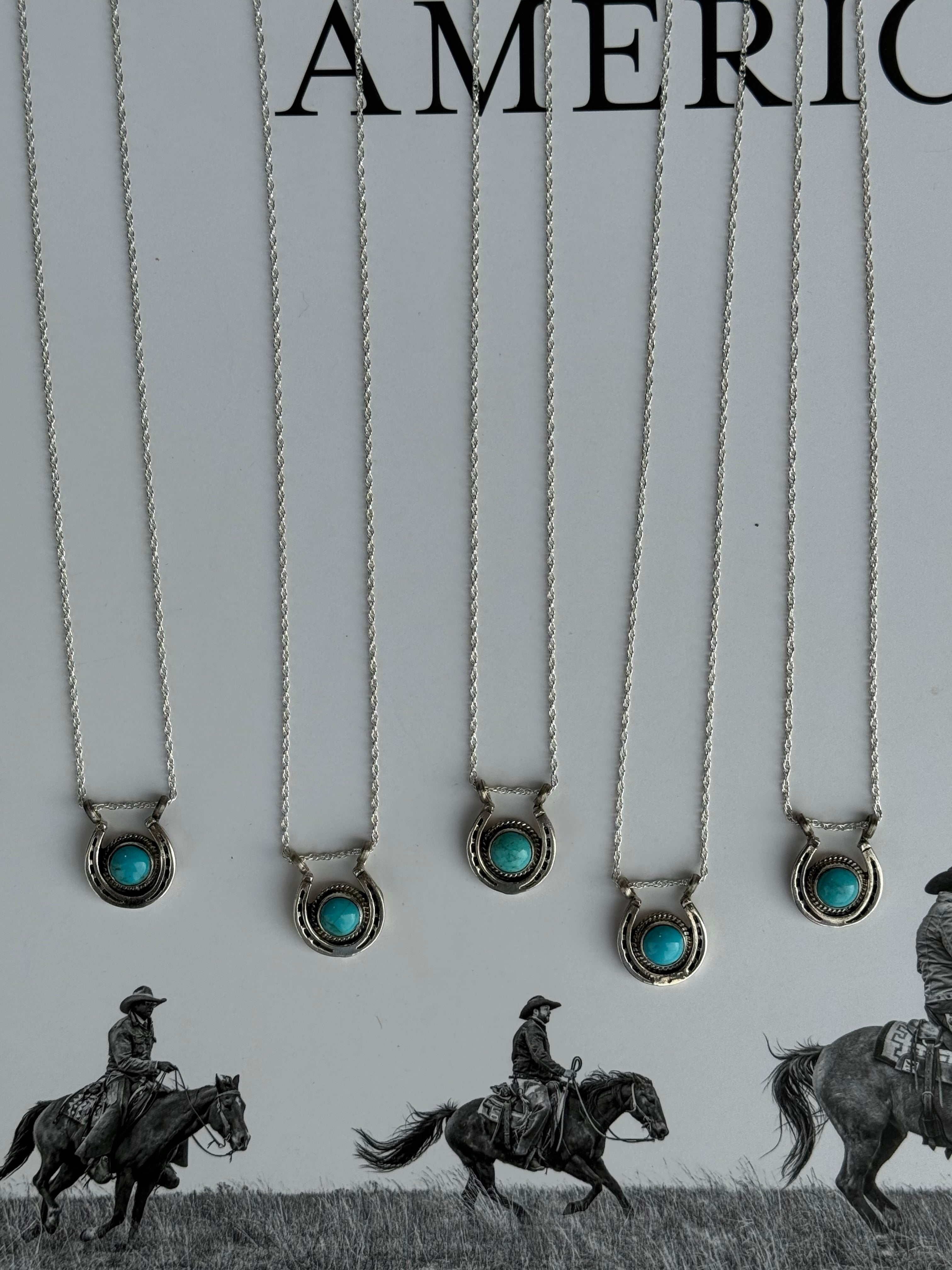 Necklaces with turquoise stones on a white card with &#39;American West&#39; branding.