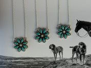 Three turquoise flower necklaces on chains with a black and white photo of two dogs and a horse in the background.