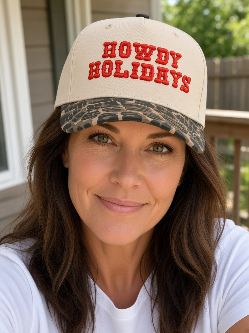 Woman wearing the Howdy Holidays cream trucker hat with red embroidered lettering and leopard print brim
