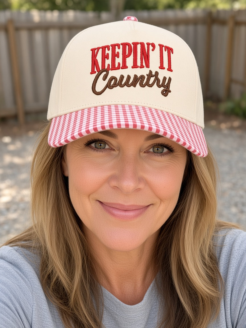 Woman wearing the Keepin' It Country cream trucker hat with red gingham brim