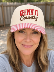 Woman wearing the Keepin' It Country cream trucker hat with red gingham brim